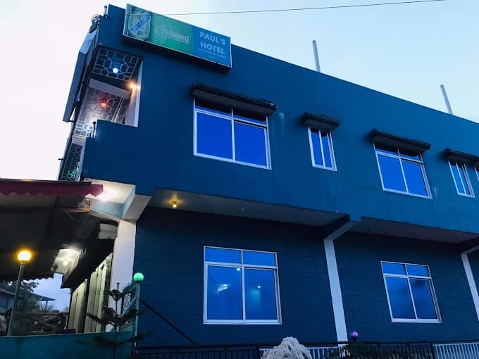 Paul's Hotel & Lodge lit up blue at dusk in Bhedetar